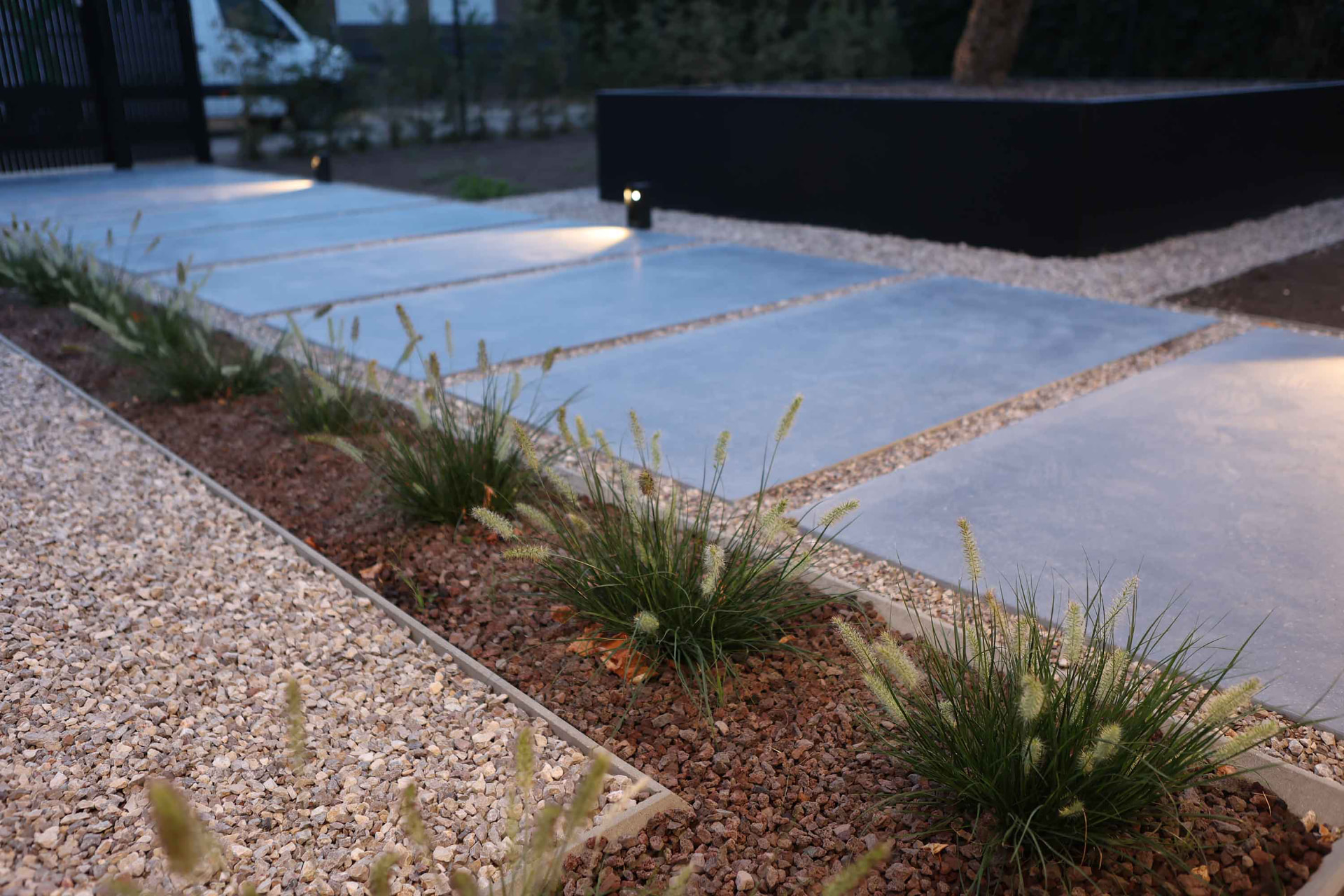 Tuin met sfeerverlichting bij avond, gerealiseerd door Hoffelijk